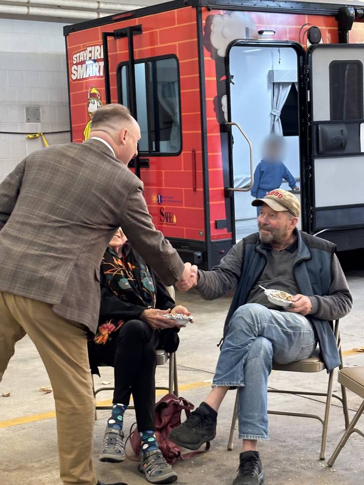 William Falcetano shaking hands with a voter at a firehouse event