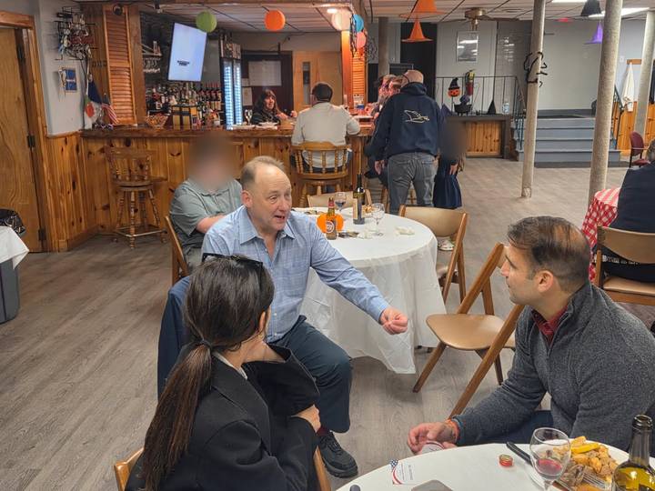 William Falcetano talking with voters at a table